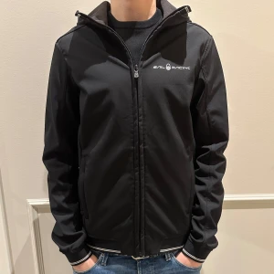 Svart jacka från Sail Racing - Stilren jacka från Sail Racing. Köpt för några månader sedan men har tyvärr blivit för liten. Perfekt nu till våren för en lite mer tunnare jacka. Köpt för 1500kr. Storlek S, Tveka inte på att höra av dig vid minsta fundering. 