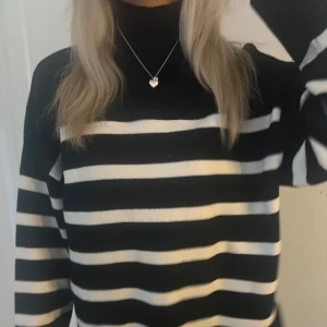 Svart och vit randig tröja - Säljer en snygg svart och vit randig tröja med polokrage. Tröjan har långa ärmar och är perfekt för en stilren look. Passar bra till både jeans och kjol. Perfekt för höst och vinter!