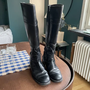 Svarta höga stövlar med snörning - Snygga svarta höga stövlar i skinn med snörning och dragkedja. Från ralp harrisson. Made in italy 