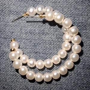 Vita pärlörhängen med gulddetaljer - Eleganta örhängen med vita pärlor i en cirkulär design. De har små gulddetaljer som ger en lyxig touch. Perfekta för att lyfta vilken outfit som helst. Ingår ej pluppar till baksidan!