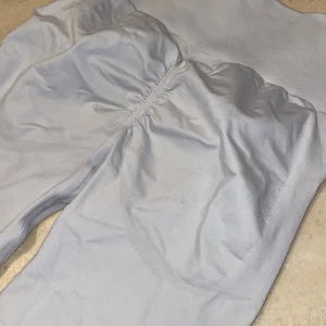 Ljusgrå/vita träningsleggings - Träningsleggings med hög midja och tight passform. Tillverkade i ett mjukt och stretchigt material. Framhäver rumpan. 