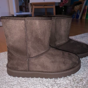 Bruna boots i mocka  - Säljer ett par bruna boots i mocka med mjukt foder. Perfekta för kyliga dagar med sin varma insida och stilrena design. De har en rund tå och en platt sula för bekväm passform.