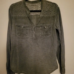 Tunika/Skjorta i bomull - Tunn grå bomullsskjorta med genombruten spets på ok och axlar. 