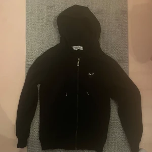 comme des garçons hoodie - Säljer en svart hoodie från Comme des Garçons med en ikonisk hjärtdetalj med ögon på ryggen. Tröjan har en dragkedja framtill . 8/10 skick Storlek S men passar Xs