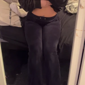 Mörk blåa JUICY - Snygga blå byxor i mjukt sammetstyg med låg midja och vida ben. Byxorna har fickor både fram och bak samt dekorativa knappar. Perfekta för en avslappnad stil. Köpte för 1900. Har använt  1 till 2 gånger dom ligger bara hemma bättre att dom blir använda. Juicy couture äkta 