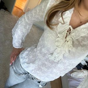 Vit mönstrad blus  - Säljer en vit tunn blus med fina blom-mönster och andra vackra detaljer från Guess i storlek S. Banden vid brösten går att justera precis som man vill. Ärmarna längst ner är breda. Har aldrig använt så den är i bra kvalité. Hör av dig vid frågor 💗