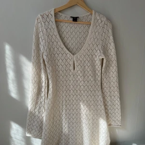 Vit stickad klänning från Lindex - Säljer en superfin vit stickad klänning från Lindex. Den har en v-ringad hals och långa ärmar. Klänningen är i nyskick och endast använd en gång. 