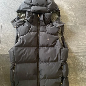Polo Ralph Lauren Väst  - Hej, säljer en riktigt fin väst från Polo Ralph Lauren i storlek S. Super inför höst och vinter då den håller värmen perfekt. Västen är i färgen Svart, ser lite gråare ut på bilder pga ljuset.  Vi frågor eller funderingar är det bara att höra av sig!