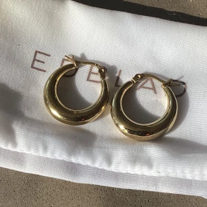 Edblad örhängen, Flow Hoops Gold - Säljer dessa fina örhängen som är i mycket fint skick! Köpt för 399 kr.  • Blank 14K gulplätering på rostfritt stål • Nickelsäkert