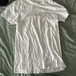 Säljer en vit t-shirt från Revenite i storlek S. Den har ett tryck på baksidan med texten 'MILFHUNTER' . Perfekt för en avslappnad stil eller som statement-plagg. T-shirten är i bomull och har korta ärmar