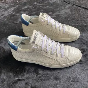 Vita unika dsquared2 sneakers med ormskinn design på hela skon med snygg blå detalj på bakdelen av skon! Gjorda av läder och är grymt snygga och sköna!  Har mycket kvar att ge!