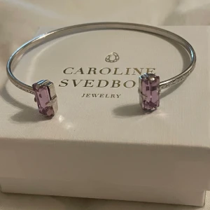 Silverarmband med lila stenar från Caroline Svedbom - Säljer detta populära silverarmbandet från Caroline Svedbom. Köpt för ca 2 år sedan men det har inte använts supermycket. Lila stenar. Säljer då jag har ett annat.
