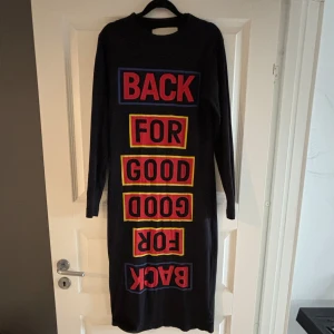 Klänning - Lång klänning med tryck på framsidan. Svart/mörkblå. Inte figursydd men något tight. 