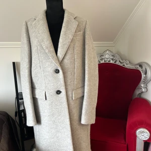 NY Hugo Boss kappa - Mycket exklusiv och NY kvalitets Hugo Boss kappa i ljusgrått säljes. Storlek 38. Passar även dig i strl S om du gillar lite oversize.