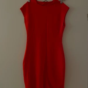 ZARA klänning - Röd tajt t-shirt klänning från ZARA. Endast använts en gång och är i mycket bra skick. Korta ärmar och kort i längden. Normal i storleken.