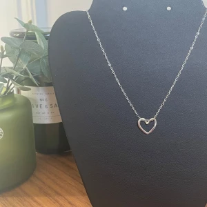 Halsband - Hjärthänge - Egengjort silverfärgat halsband i rostfritt stål. Hjärtat går att förflytta på kedjan så att det kan ha olika utseenden. 🩶Kolla gärna resten av mina annonser för samfrakt.