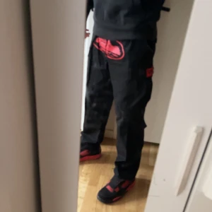 Svarta cargobyxor med röda detaljer - Säljer ett par svarta cargobyxor med cortez logga. De är riktigt sköna och de passar dig som gillar cargos. Skriv för mer info ;)