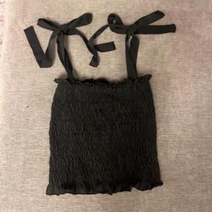 Svart topp - Supersöt svart topp från Gina tricot i stl S. Toppen har knytband som man kan justera själv vad som passar en. Perfekt både till fest eller vardags💕