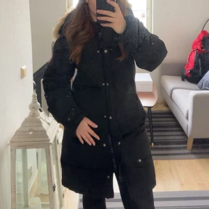 Canada goose - DAM jacka storlek L men passar M   Har ett litet håll över knät som syns på bilden.Går att sy ihop det !.    Den är äkta finns inget kvitto men finns märkena inne i jackan som också finns på bilden :)   Priset går att diskutera vid snabb affär !