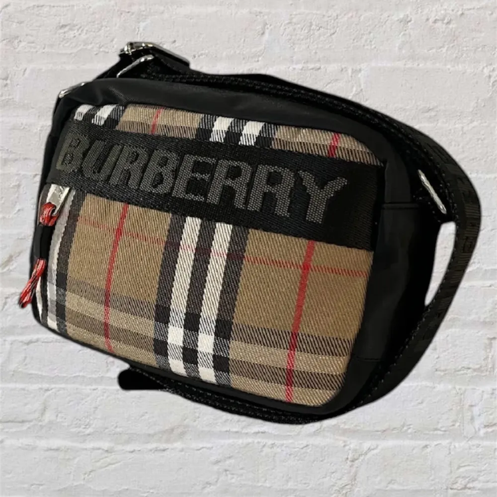 Hej! Detta är en burberryväska i hög kvalité! Den har en skjusterbar axelrem som det står burberry på.  Om du har några frågor så finns jag i chatten!😁. Väskor.