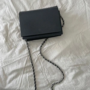 Svart axelremsväska  - Svart axelremsväska som är perfekt att ha. Jätte bra skick och knappt aldrig varit använd