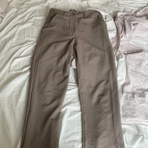 Beige byxor i storlek XS - Säljer ett par stilrena beige byxor i storlek XS.Det finns en liten defekt på framsidan längst ner, men inget som märks.
