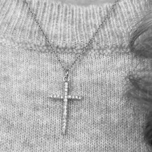 Silverhalsband med korshänge - Säljer ett elegant silverhalsband med ett glittrande korshänge. Hänget är täckt med små gnistrande stenar som ger en lyxig känsla. Perfekt för både vardag och fest!