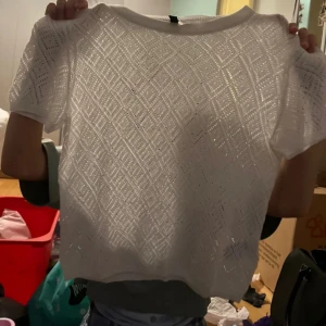 Vit stickad topp från H&M Divided - Säljer en superfin vit stickad topp från H&M Divided. Den har ett snyggt diamantmönster och korta ärmar. Perfekt för både vardag och fest! 🖤