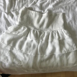 Vit volang kjol - En gullig vit volangkjol som inte används längre  Den har tre slitningar men inget man lägger märket till💕💕