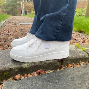 Stilrena vita sneakers - Dessa vita snygga Champion sneakers går aldrig fel till en outfit! Bara använd en gång och är där med i fint skick. Storleken är 38,5. Nypris är 750 och vi säljer de för endast 349! Skriv vid funderingar! 😍
