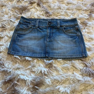 Vintage minikjol - Vintage minikjol i jeansmaterial. Midjemått är 40cm. Längd är 27-29cm.