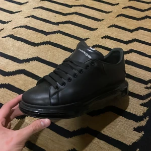 Mcqueen -  Alexander McQueen's Larry sneakers feature an exaggerated yet minimalistic oversized silhouette. Crafted from smooth leather with an elevated and transparent rubber sole, they feature the brand's logo on the heel counter and tongue. Size 46 fit 45.