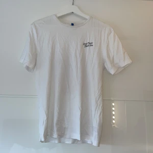 Vit t-shirt från H&M Divided - Säljer en vit t-shirt från H&M Divided i storlek S.  Perfekt för sommardagar eller avslappnade tillfällen. T-shirten är i bomull och har en normal passform!