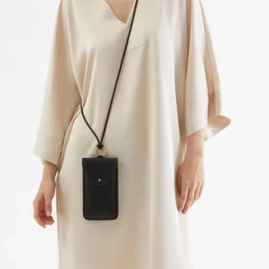 Satinklänning - Kaftan klänning i silkeslen satin i rymlig passform och midilängd. Klänningen har slits på båda sidorna samt två sidfickor. Korta och vida ärmar. Använd vid 1 tillfälle. Nyskick. 