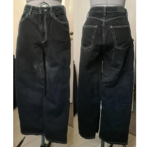 Straight leg jeans svarta med vita sömmar 27 - Känns som nyskick, begagnade. 100% bomull. Fläck lite under grenen, vet inte vad det är eller om det går bort i tvätt (ser urblekt ut). För korta för mig tyvärr. Innerben: 60, benöppning vidd: 24.