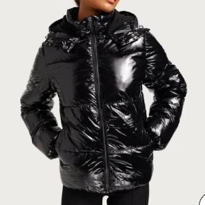 Glansig vinterjacka  - Supersnygg vinter jacka från Nelly! Säljer då den inte längre kommer till användning🥰nyskick och därav inga defekter, skriv privat vid fler frågor