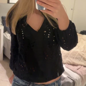 Svart blus med spetsdetaljer - Säljer en svart blus med spetsdetaljer och v-ringning. Blusen har långa ärmar och en luftig passform, perfekt för en stilren look. Passar bra till både jeans och kjol.❤️ Jätte fint skick