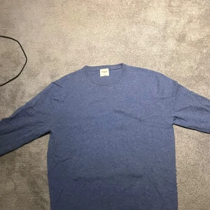 Blå kashmirtröja från John Henric - Ljusblå Kashmir tröja i storlek M från John Henric. Köpt för cirka ett år sedan men har bara användts ett par gånger. Inga defekter förutom lite missfärgning på lappen. Nypris: 2200. Mitt pris: 600. Jag är 188 och väger 70kg och den sitter väldigt bra på mig, dock kanske lite kort i ärmarna