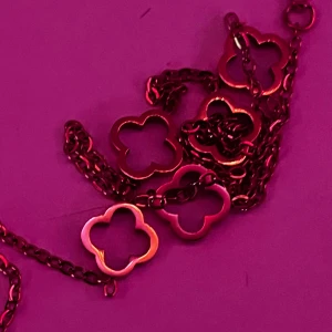 Guldhalsband med fyrklövermotiv, Rostfritt stål pläterad med 18K guld - Elegant guldhalsband med flera fyrklöverformade länkar. Perfekt för att lägga till en touch av stil och lycka till din outfit. Halsbandet har en tunn kedja som ger ett delikat och sofistikerat utseende.