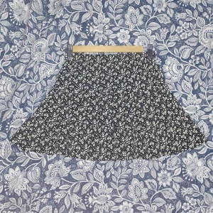 Svart blommig kjol - Säljer en svart kjol med ett sött blommigt mönster i vitt. Kjolen har en kort längd.