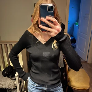 Svart ribbad tröja från Tiger of Sweden - Snygg svart ribbad tröja från Tiger of Sweden med långärmad design och v-ringad hals. Perfekt för en stilren look. Passar bra till både jeans och kjol. Som ny! Nypris 1899kr