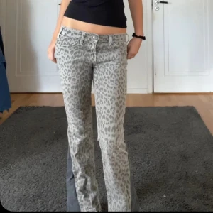 Grå leopardmönstrade jeans - Snygga grå jeans med leopardmönster och en unik design  Perfekta för dig som vill sticka ut med en djärv stil.