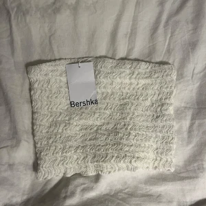 Vit ribbad tubtopp från Bershka - Säljer en vit tubtop från bershka då jag inte får någon användning utav den. Storlek S. 