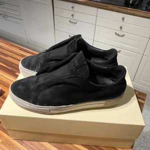 Arigatos - Snygga svarta sneakers från Arigato i mocka med en stilren design. Skorna har en vit sula som ger en snygg kontrast och en diskret logga på plösen. Perfekta för en casual look.
