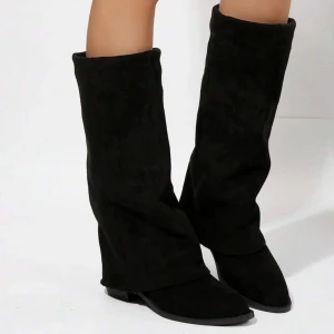 Svarta mockastövlar - Snygga svarta stövlar i mocka med en stilren design. De har en spetsig tå och en låg klack, vilket ger en elegant look. Perfekta för att komplettera din outfit under höst och vinter. Använda en gång