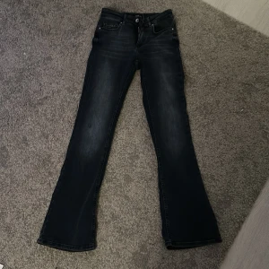 Svarta bootcut jeans från ONLY - Snygga blåa bootcut jeans från ONLY med en klassisk femficksdesign. Jeansen har en knapp och dragkedja framtill och är perfekta för en stilren look. De har en lätt tvättad effekt som ger en cool touch. Helt oandvända, fick i present men passar ej!
