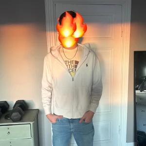 Vit huvtröja från Polo Ralph Lauren - Säljer en stilren vit huvtröja från Polo Ralph Lauren. Tröjan har en dragkedja framtill och en klassisk huva. Perfekt för en avslappnad look. 🕶️