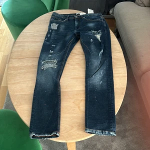 Zara jeans  - Jag säljer ett par mörkblå zara jeans med slitnigar som inte går och få tag på mer. det är storleken 40 och ben längden är 76 cm. Skriv om minsta funderingarna  priset är inte spikat i sten.