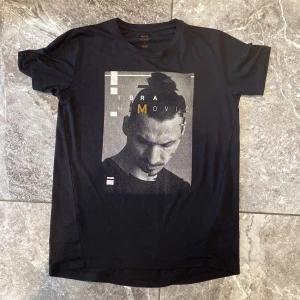 Svart t-shirt med tryck - Säljer en svart t-shirt med ett coolt tryck av en person med texten 'IBRAHIMOVIC'. T-shirten är kortärmad och har en normal passform. Perfekt för vardagsbruk eller för att visa upp din stil på stan!