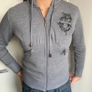 Y2K zip up hoodie - Jättesnygg alternativ grå hoodie! Fint skick! Saknar tre stenar på trycket på ryggen, men inget man märker tydligt! Säljer vidare för att den inte passar mig i storlek. 